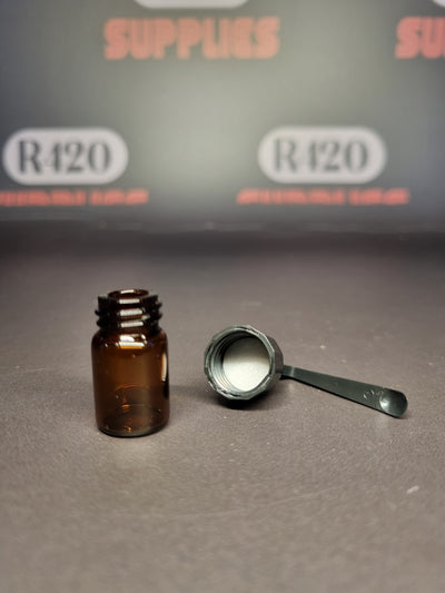 Kleine glazen injectieflacon met schroefdop en lepel